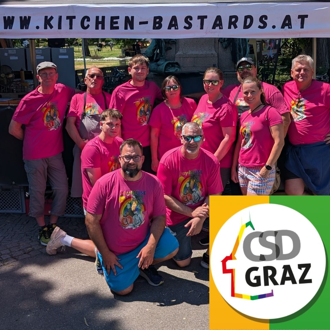Team von Kitchen Bastards als offizieller Caterer beim CSD Graz 2026, gemeinsam vor dem Stand in pinken Shirts mit Pride-Motiv